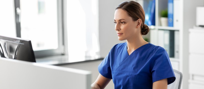 Healthcare Services Administration professional working at a desktop computer.