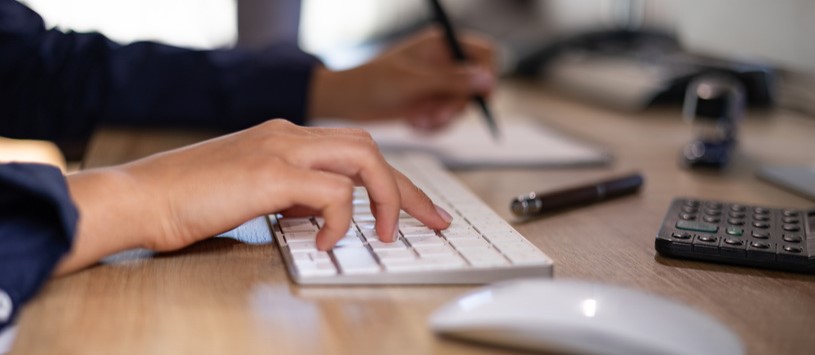 Business Management/Marketing student typing on a computer keyboard.